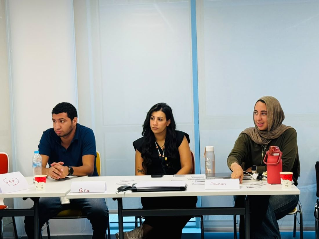 Three participants listening at a table